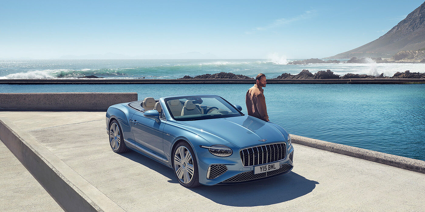 Bentley Gold Coast (Australia) New Bentley Continental GTC Azure convertible front view in Light Windsor blue paint with 22 inch ten spoke wheels parked by the sea in the sunshine
