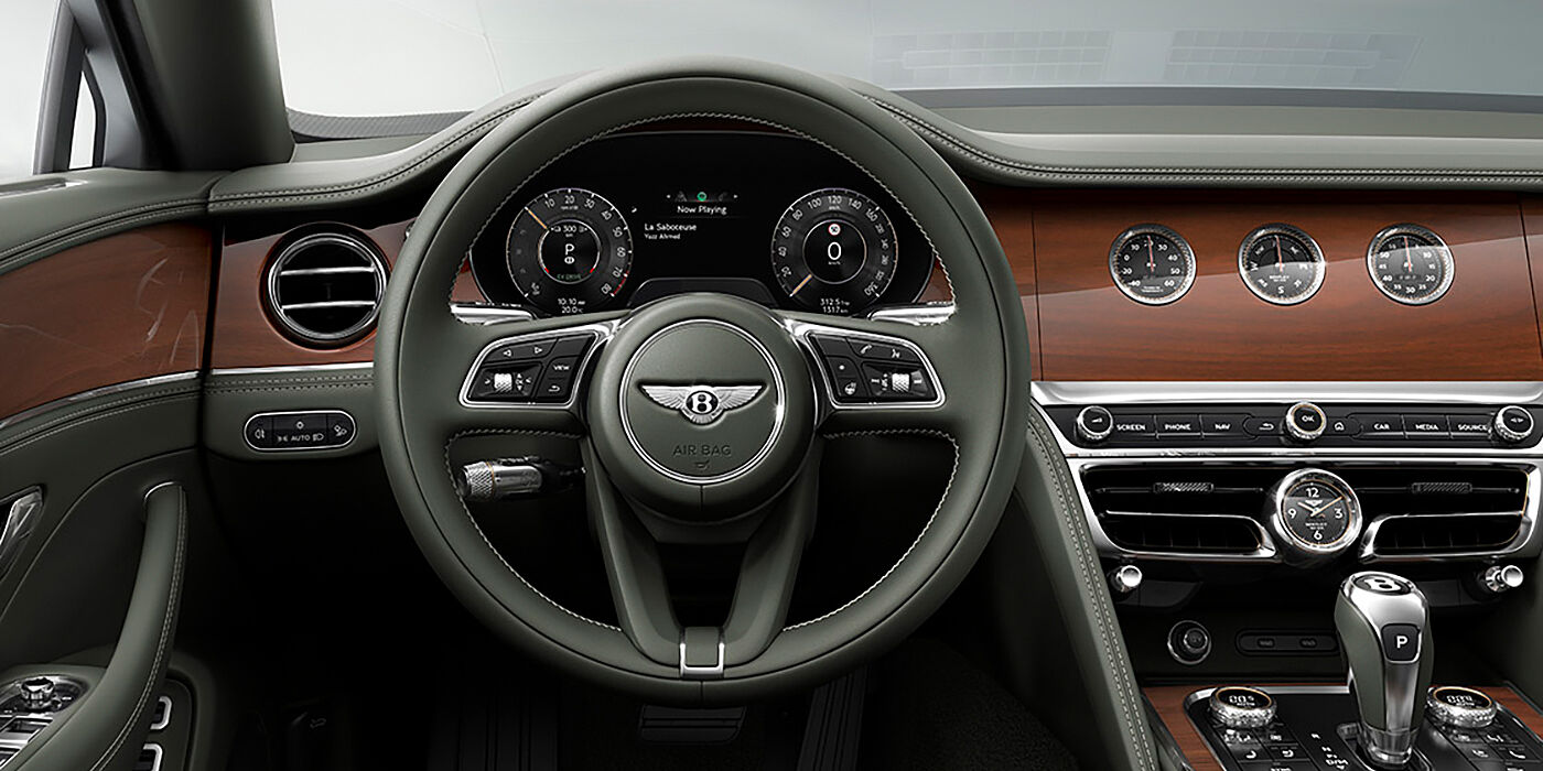 Bentley Gold Coast (Australia) New Bentley Flying Spur sedan front cabin in Cumbrian Green hide and Crown Cut walnut veneer showing steering wheel and Rotating Display with three clocks on face