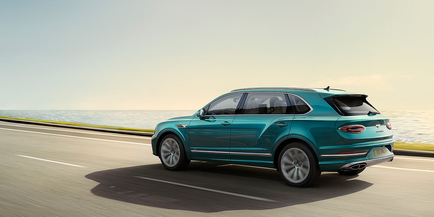 Bentley Gold Coast (Australia) Rear view of a Topaz blue Bentley Bentayga EWB Azure, cruising along a sea side road.