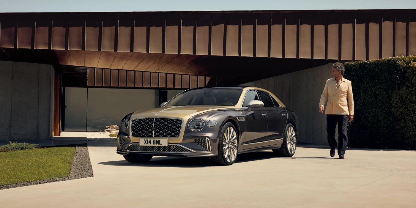 Bentley Gold Coast (Australia) Bentley New Flying Spur Mulliner V8 hybrid sedan front three quarters in Rose Gold over Magnetic paint, parked near modern home