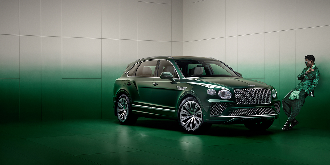 Bentley Gold Coast (Australia) Wisdom K leans against wall next to Bentley Bentayga Extended Wheelbase Atelier Edition SUV in Light Emerald green paint