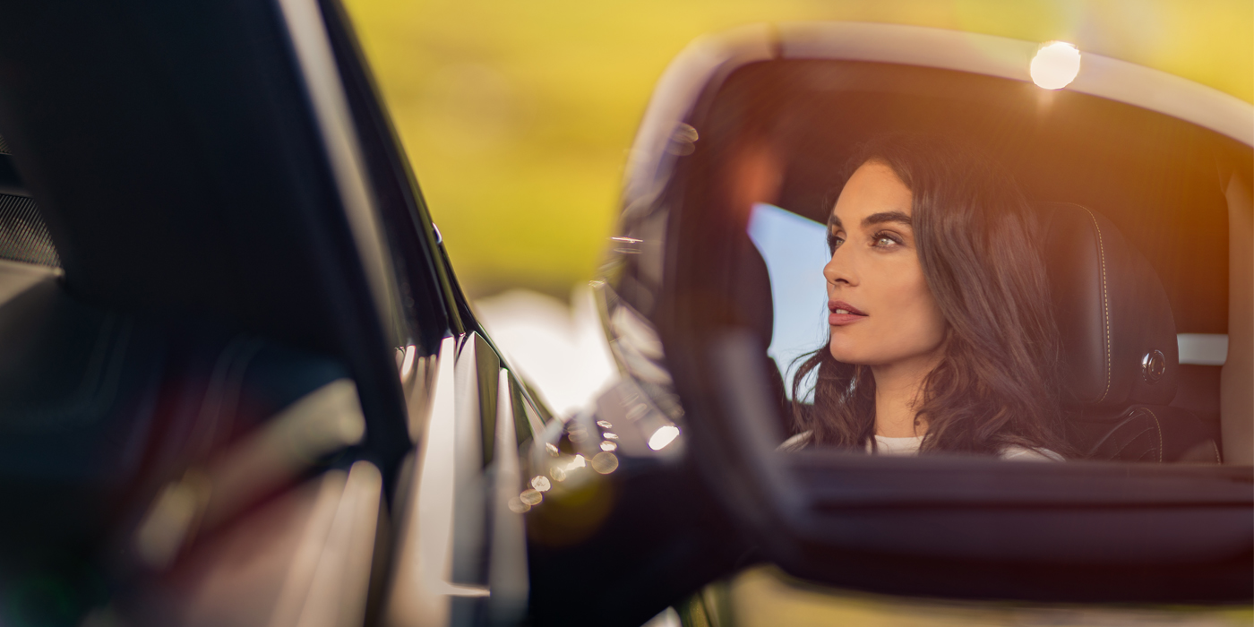 Bentley Gold Coast (Australia) profile of dark haired woman's face in mirror of Bentley car in sunlight