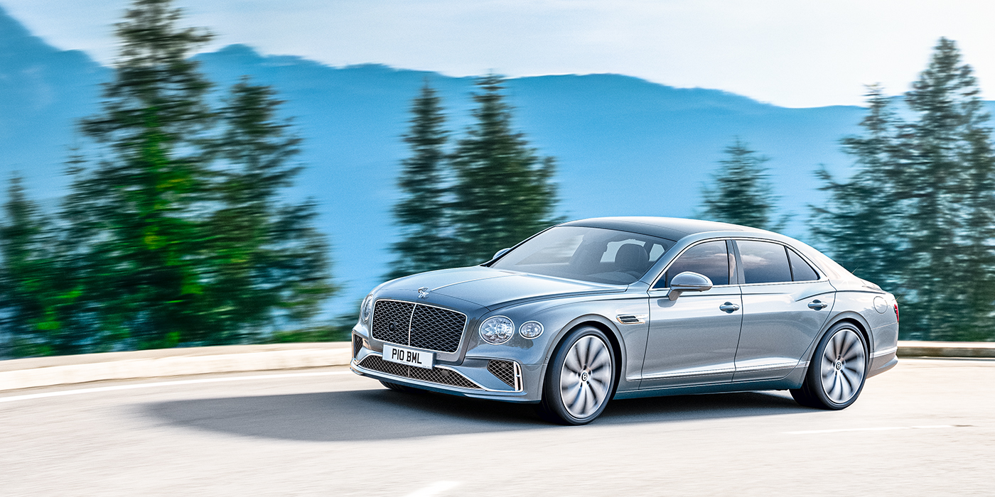 Bentley Gold Coast (Australia) New Bentley Flying Spur sedan side view in Silverlake paint with ten spoke wheels and chrome matrix grille driving dynamically on a mountain road