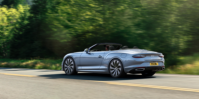 Bentley Gold Coast (Australia) New Bentley Continental GTC convertible side view in Silverlake paint with 22 inch ten spoke wheels driving dynamically on a country road