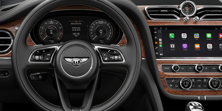 Bentley Gold Coast (Australia) Bentley Bentayga SUV front interior detail of steering wheel and driver screens surrounded by Beluga black hide and Crown Cut Walnut veneer